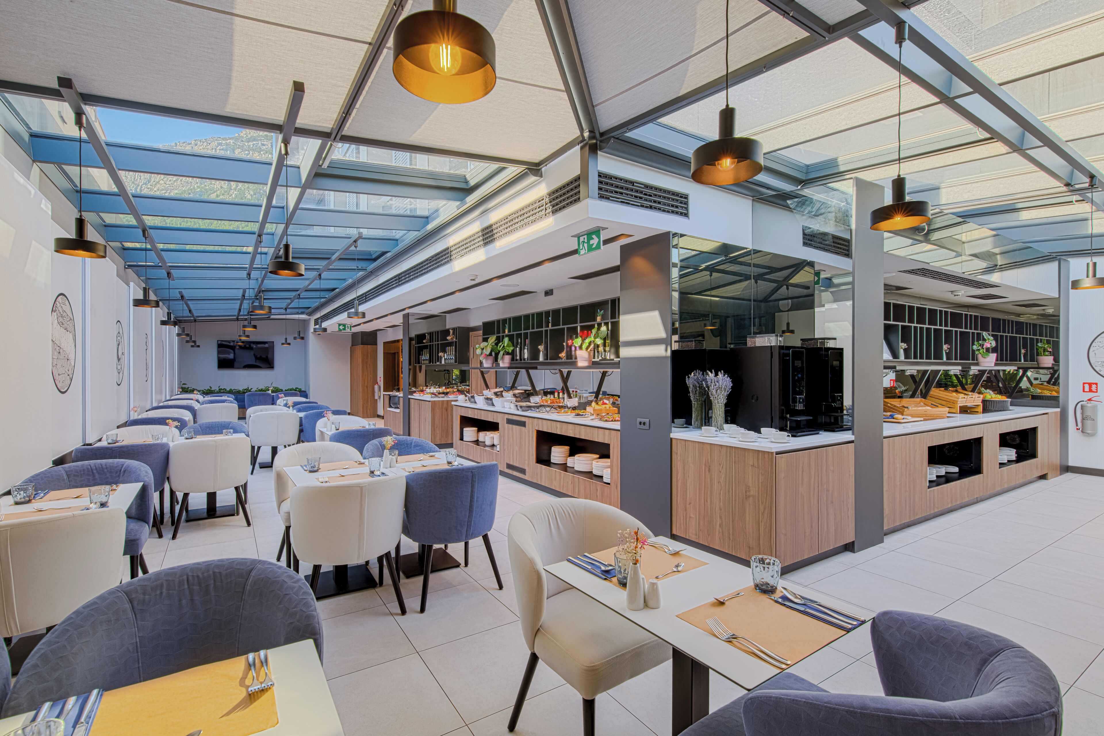 Un restaurant moderne doté d’une verrière, de plusieurs espaces de restauration et d’une cuisine centrale.