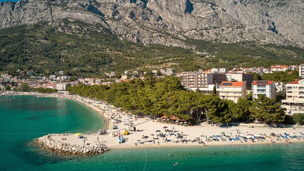 A coastal town with a beach, buildings, and mountains in the background. - Boutique hotel Noemia (Baska Voda)