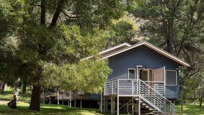 A single-story house with a wooden deck and a staircase leading to a covered porch. - "Parkview West" hosted by Halls Gap Accommodation (Halls Gap)