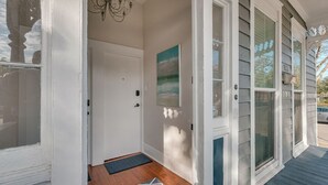 A front porch with a door, a mat, and a painting. - Downtown Victorian Near Forsyth, Nightlife, Enmarket Arena by Lucky Savannah (SAVANNAH)