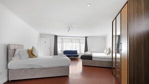Ein modernes Hotelzimmer mit zwei Betten, einem großen Spiegel und einem Kleiderschrank.