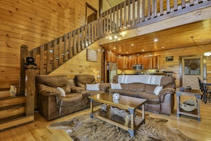 Cozy cabin interior with a living area, kitchen, and dining space.
