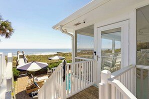 Ein Strandgrundstück mit einer Terrasse, Sitzmöglichkeiten im Freien und Blick auf den Ozean.