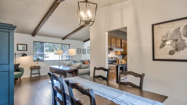 Un espace repas comprenant une longue table, des chaises et un luminaire suspendu.