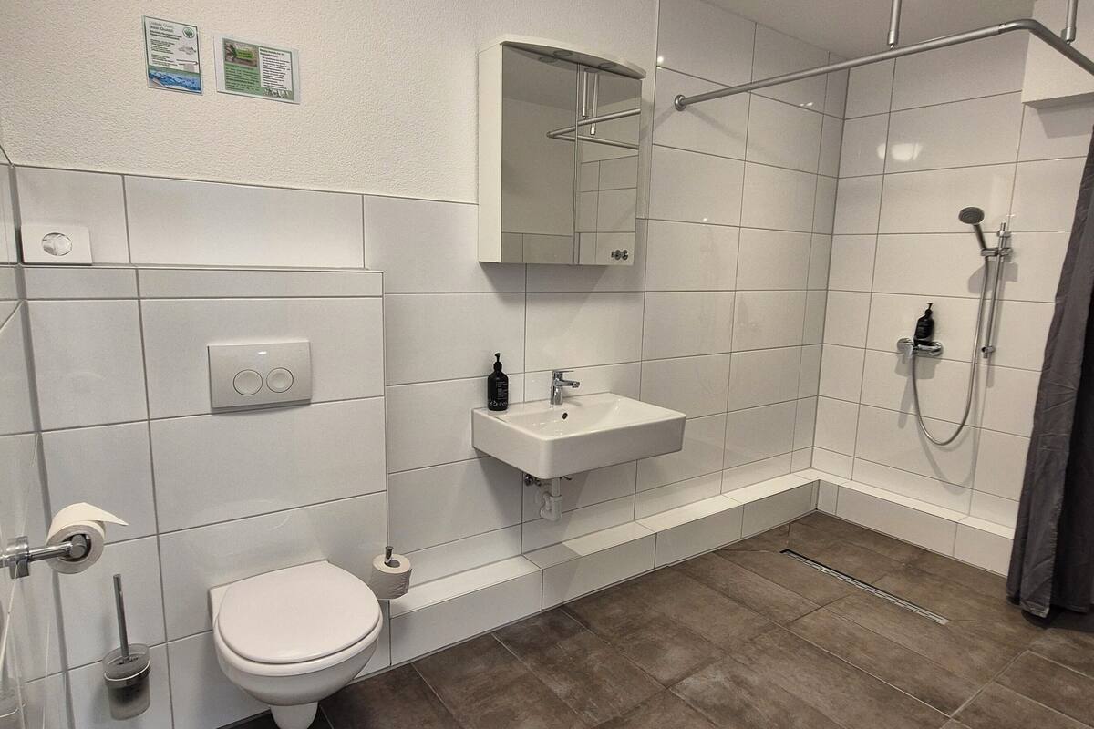 A modern bathroom with a toilet, sink, and shower.