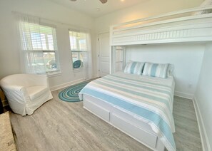 A bedroom with a bed, a chair, and a window.