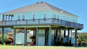 A two-story house with a balcony, a covered porch, and a small attached shed.