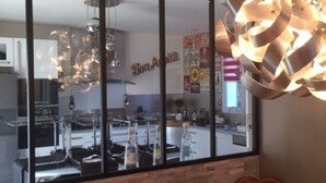 A modern kitchen with a large window, a wooden wall, and a unique light fixture. - Spacious villa with private pool, summer kitchen, plancha barbecue near Bayonne (Mouguerre)