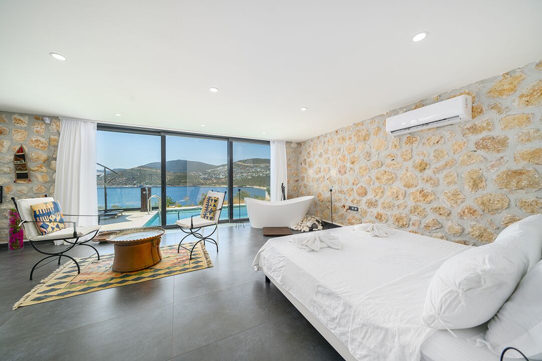 Une chambre à coucher moderne avec un grand lit, une baignoire et une vue sur la mer.