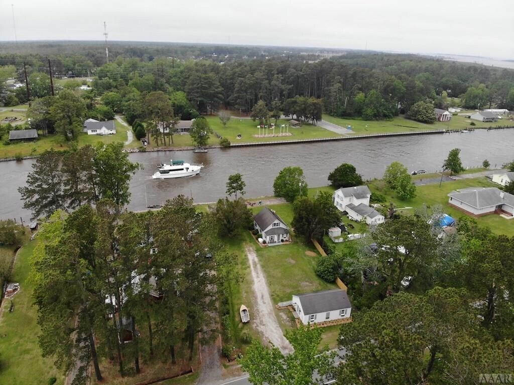 A river with a boat, surrounded by residential houses and greenery.