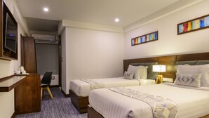 A hotel room with two beds, a desk, a chair, and a TV. - Hotel Zakaria International (Dhaka)