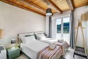 A double room with two beds, a wooden ceiling, a large window with a view, a hanging light fixture, and a wooden hanger. - Villa Belvedere (Giarratana)
