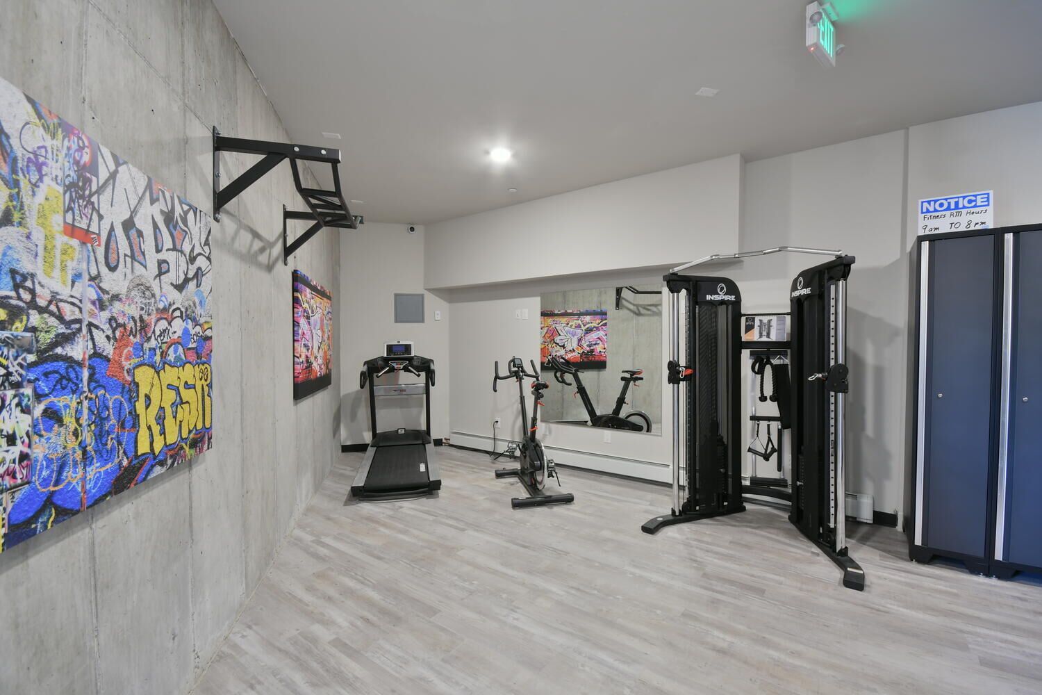 A gym with a treadmill, stationary bikes, and a weight machine.