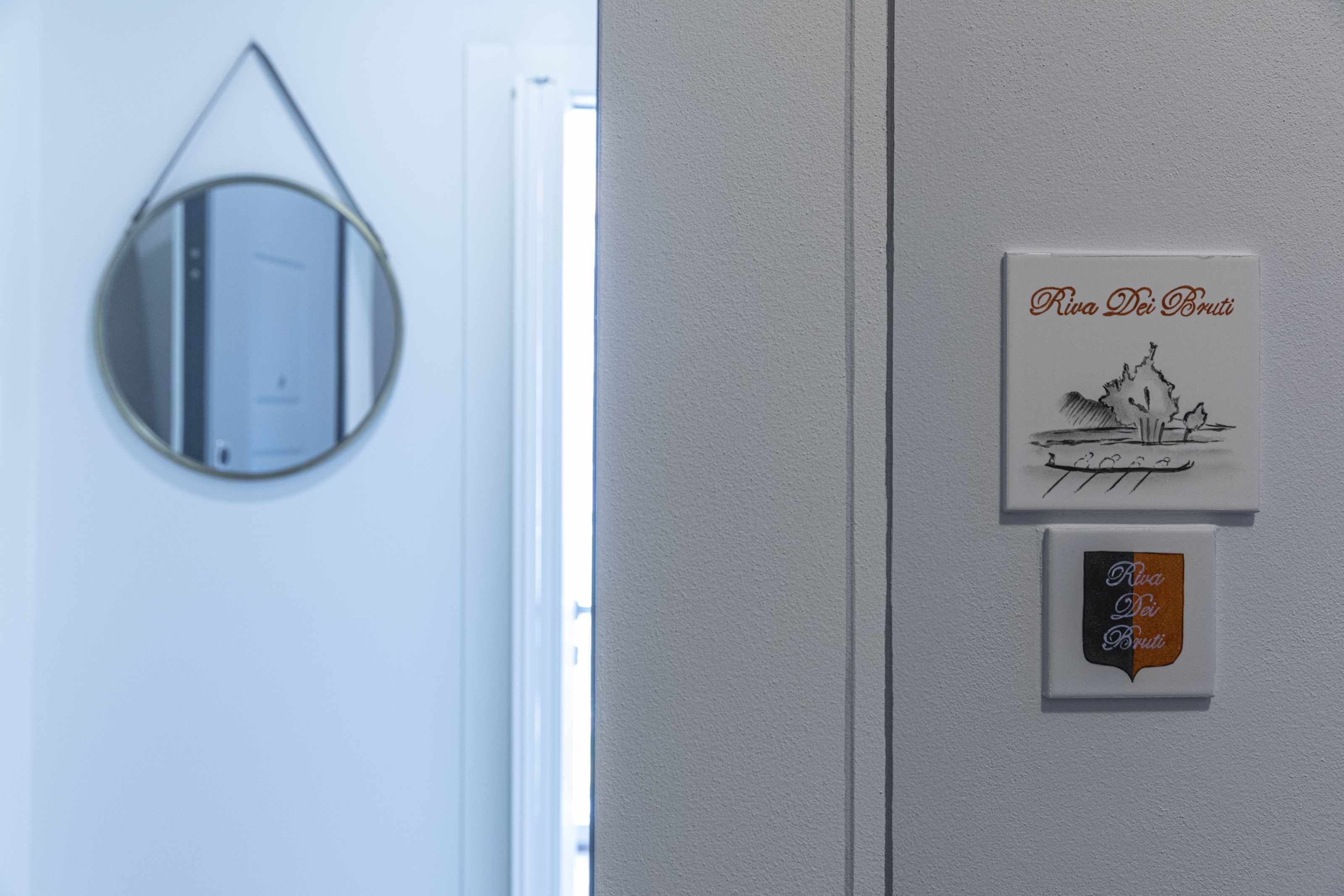 Eine Tür mit einem runden Spiegel und zwei Schildern mit Schrift.