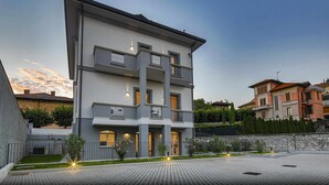 A multi-story residential building with balconies and a paved courtyard. - CA ’DEL RE’ SCARTOZZ Riva dei Bruti (Gavirate)