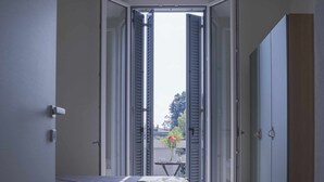 A bedroom with a bed, a wardrobe, and a door leading to an outdoor area. - CA ’DEL RE’ SCARTOZZ Riva dei Bruti (Gavirate)