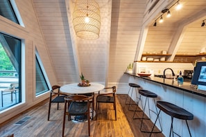Enjoy meals in the spacious kitchen and dining area with a high ceiling and exposed beams.