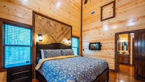 A wooden cabin bedroom with a bed, nightstands, and a dresser. - # Kick Back Shack  ## Luxury Broken Bow Cabin with Hot Tub, Pool Table, EV Charg (Broken Bow)