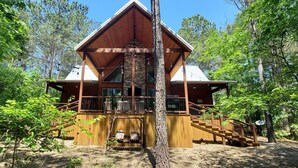 A cabin with a wooden exterior, a stone foundation, and a staircase leading to a deck. - # Kick Back Shack  ## Luxury Broken Bow Cabin with Hot Tub, Pool Table, EV Charg (Broken Bow)