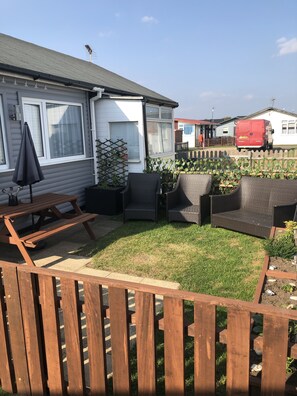 Un jardin arrière d’une maison, comprenant une terrasse en bois, un espace patio et un jardin.