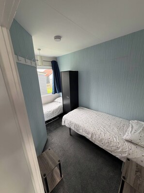A compact room with two single beds, a wardrobe, and a small desk. - Chalet 91A South Shore Bridlington, Sleeps 4 (Bridlington)