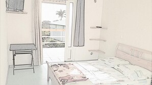 Ein Schlafzimmer mit Bett, Schreibtisch und einem Fenster mit Vorhängen.