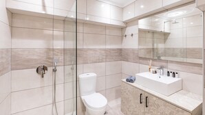 A modern bathroom with a glass shower enclosure, a white toilet, and a vanity with a mirror. - Urban Loft - Stylish One Bedroom Apartment (Κέρκυρα)