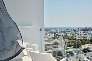 Un balcón con vistas a la ciudad y al mar.