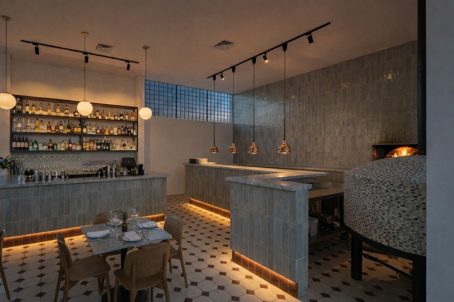 Un espace bar moderne avec un sol carrelé, un comptoir et des luminaires suspendus.