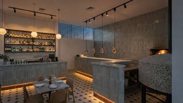 Un espace bar moderne avec un sol carrelé, un comptoir et des luminaires suspendus.