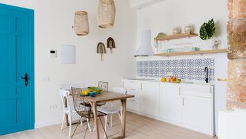 Enjoy cooking in this well-equipped kitchen with an oven, wooden dining table, and ample storage.