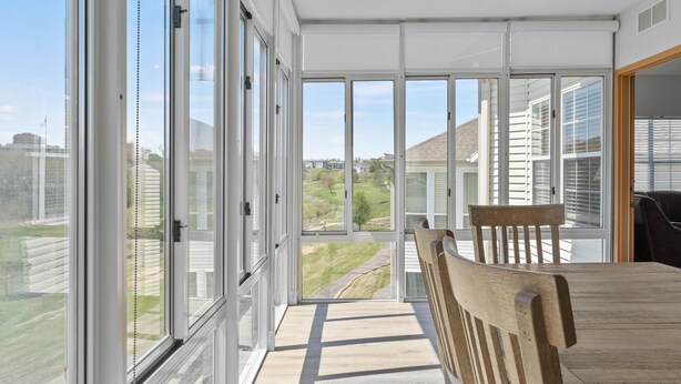 A room with large sliding glass doors, a wooden table, and a chair. - 3 Bedroom, 3 Bath Golf Condo with Beautiful Course View from All-Season Sunroom (Branson)