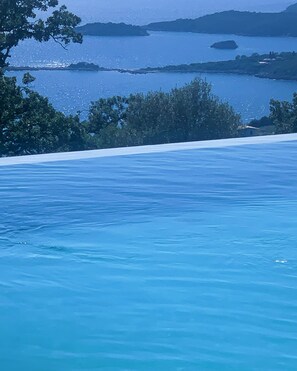 A clear view of a swimming pool with a backdrop of trees and distant landforms. - Alon Sevou Boutique Hotel (Igoumenitsa)