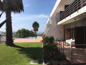 Uma casa moderna com piscina, varanda e vista para a paisagem.
