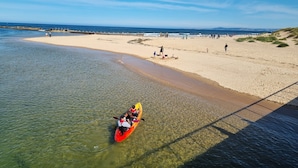 Um caiaque numa praia clara com areal e águas calmas.