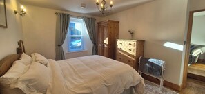 A bedroom with a bed, a dresser, a mirror, and a window with curtains. - The Coal Office, Aberlour (Aberlour)