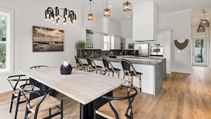 A modern kitchen with white cabinetry, a central island, and pendant lighting.