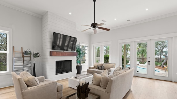 A spacious living room with a fireplace, comfortable seating, and large windows offering a view of the outdoors.