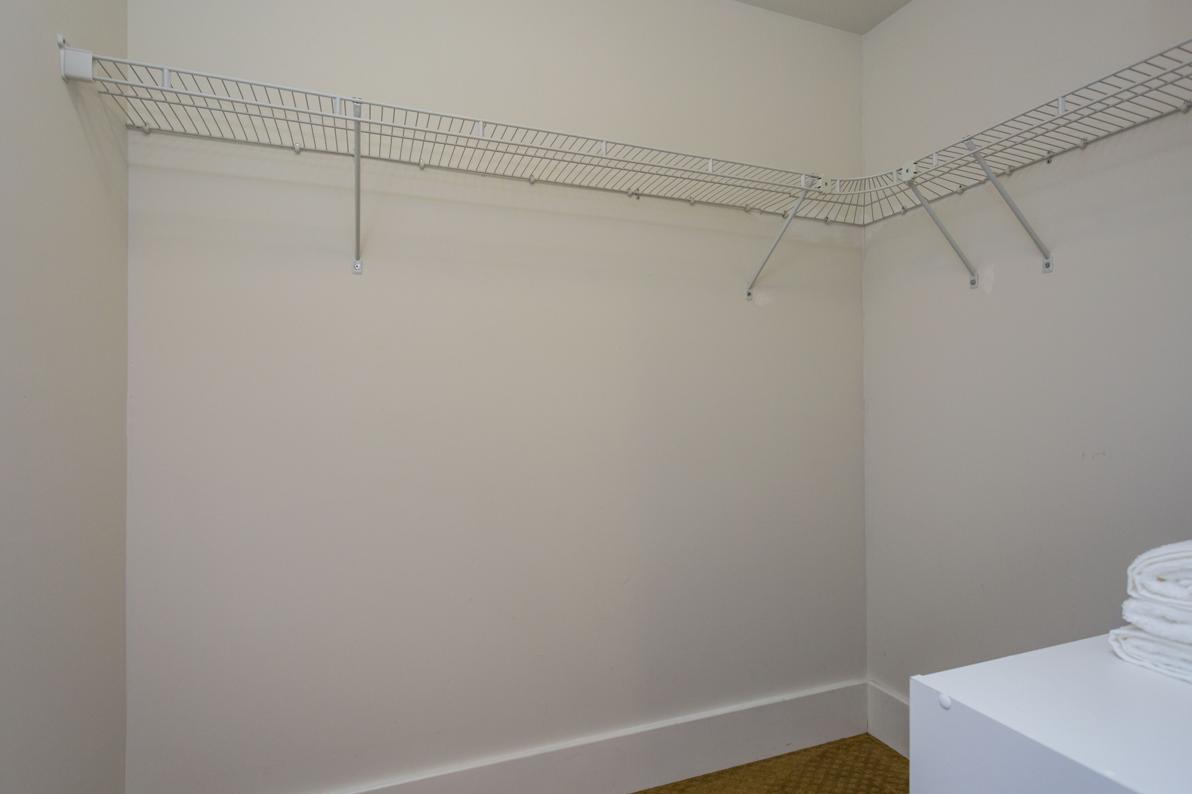 A laundry area with a metal drying rack and a white washing machine.