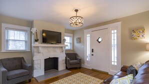 A living room with a fireplace, a television, a sofa, and a patterned rug. - Red Nashville Beauty 3BD/2BT - 12Min from Downtown (Nashville)