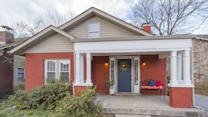 A two-story house with a front porch, a brick exterior, and a wreath on the door. - Red Nashville Beauty 3BD/2BT - 12Min from Downtown (Nashville)