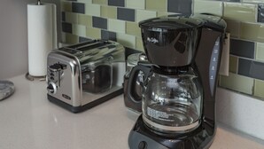 Une cuisine équipée d’une machine à café, d’un grille-pain et d’un rouleau d’essuie-tout.