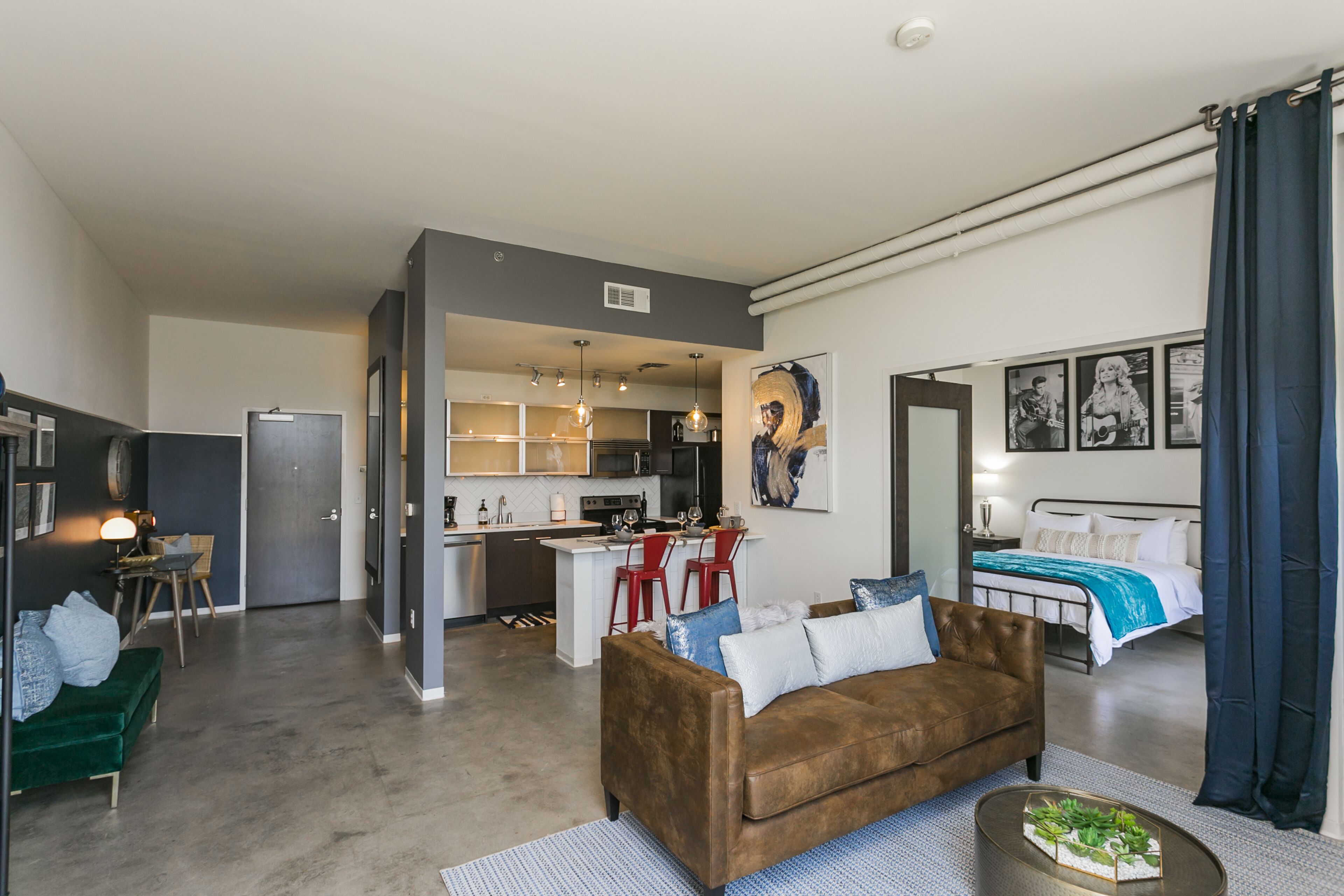 Un appartement moderne comprenant un salon, une cuisine et une chambre.