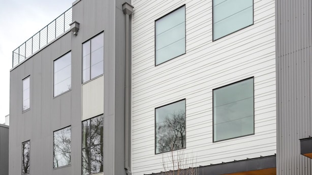 En modern byggnad med flera våningar, stora fönster och ett platt tak.
