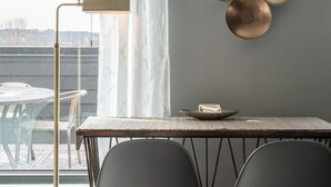 Ein Essbereich mit Tisch und Stühlen, einem Wanddekor und einer Stehlampe.