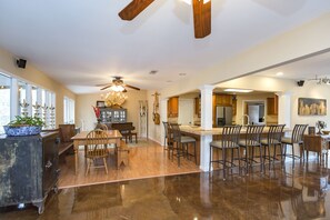 A spacious kitchen with a central island, wooden chairs, and a dining area with a table and chairs.