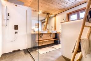 Deluxe chalet | Badkamer | Een douche, een haardroger, handdoeken