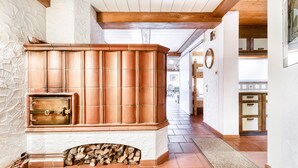 Une cheminée en pierre avec un revêtement extérieur en cuivre, un plafond en bois et un sol carrelé.