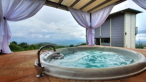 A hot tub on a patio with a view of the landscape.