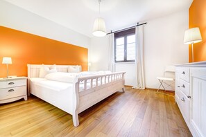 A bedroom with a bed, nightstands, a dresser, and a window with curtains. - Mountain Lodge by A-Appartements (Brand)
